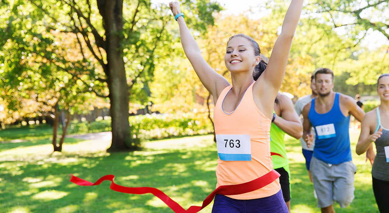 Young woman smiling while running a marathon, active and comfortable.