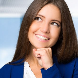 Woman smiling and thinking about whether to have cosmetic surgery.
